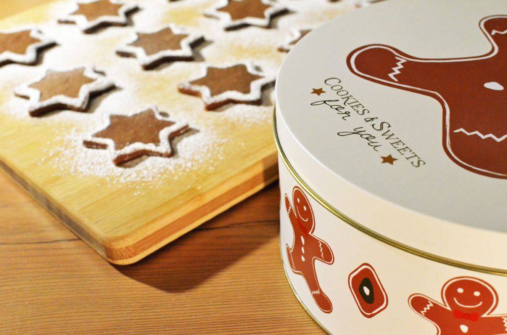 Gingerbread starts next to a gingerbread man-decorated tin. Christmas food guilt.